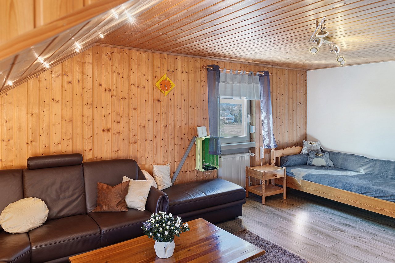 Wohnbereich mit Ecksofa unter der Dachschräge, Fewo Tanja’s Blumenparadies in Hollfeld, Bayern