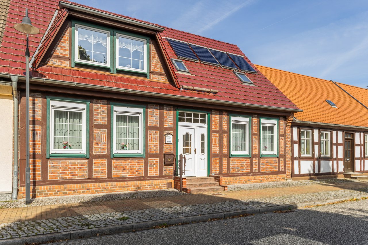 Rot geklinkertes Fachwerkhaus mit grünen Fensterrahmen im Sonnenlicht, Ferienwohnung Eins in Bad Wilsnack, Brandenburg, Bad Wilsnack, Prignitz, Brandenburg