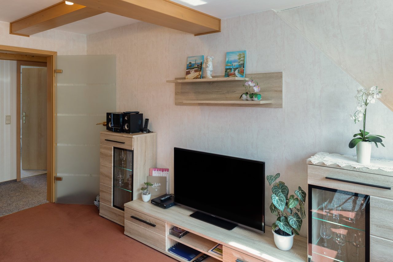 Wohnwand mit Fernseher unter Holzbalken, Ferienwohnung Zwei in Bad Wilsnack, Brandenburg, Bad Wilsnack, Prignitz, Brandenburg