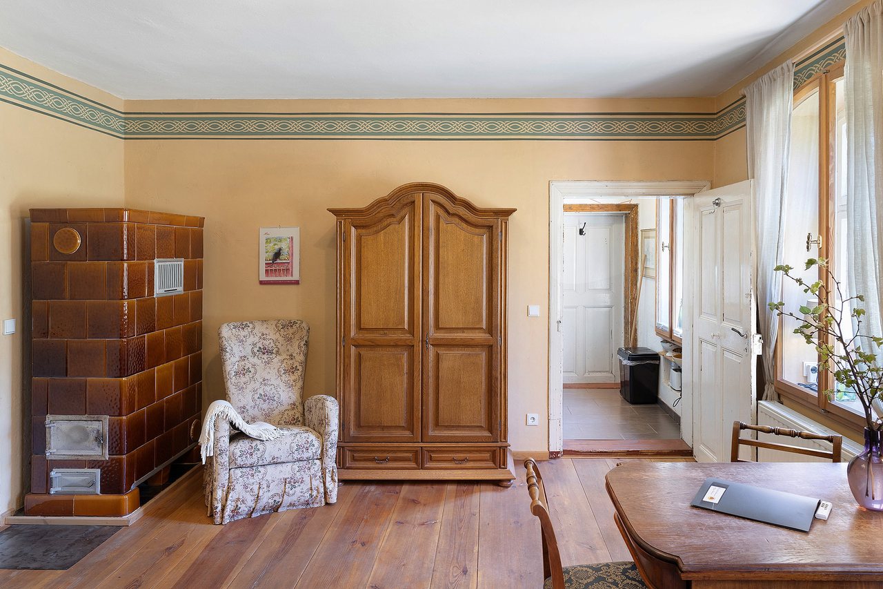 Wohnzimmer mit Sessel und Kachelofen, Ferienwohnung am Roten Schloss in Baruth/Mark, Brandenburg
