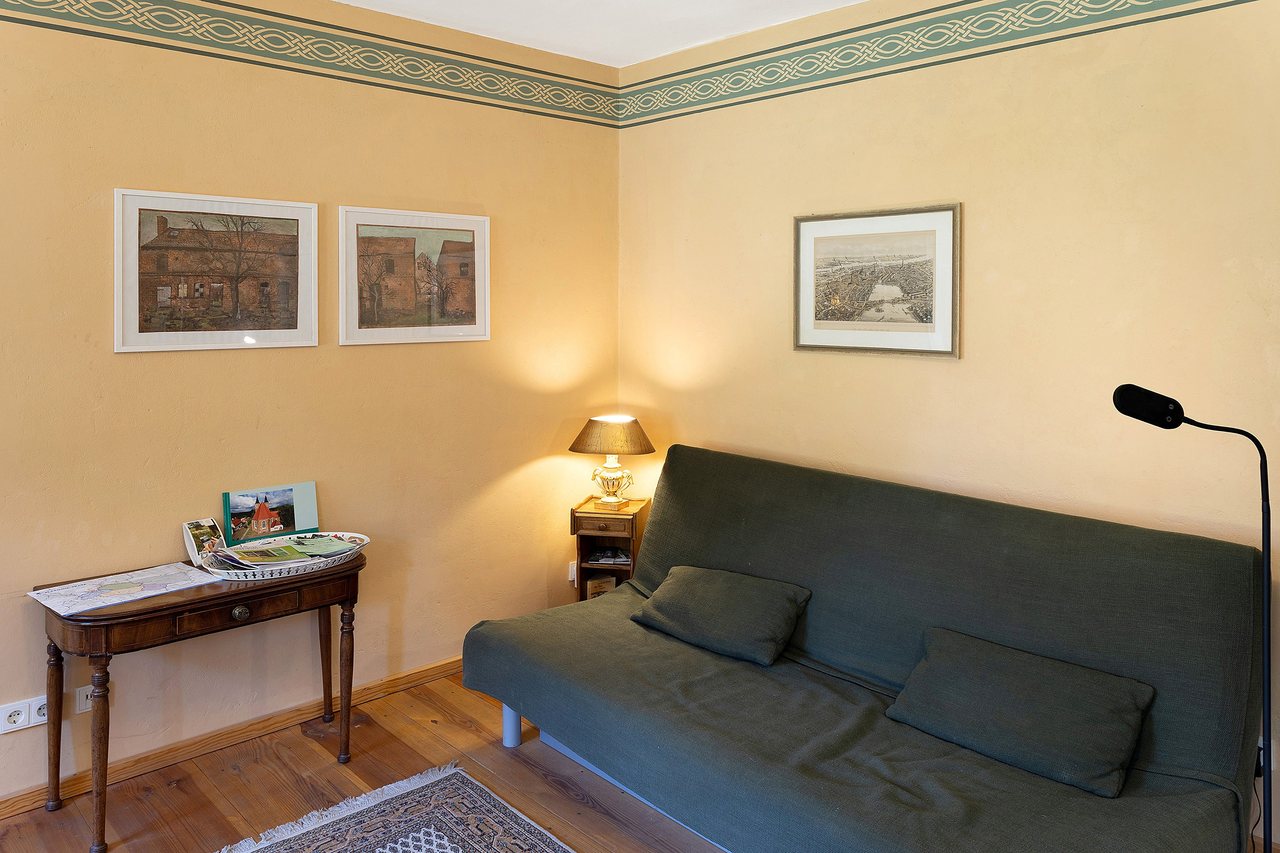 Wohnbereich mit Schlafsofa und Sekretär, Ferienwohnung am Roten Schloss in Baruth/Mark, Brandenburg
