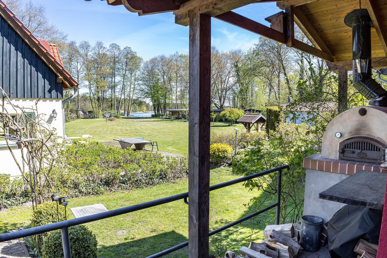 Überdachte Terrasse mit Grillkamin und Gartenblick, Ferienhaus Haussee in Himmelpfort, Brandenburg