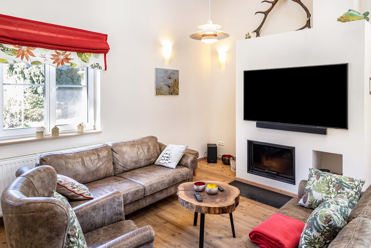 Wohnzimmer mit Sofa und Kamin, Ferienhaus Haussee in Himmelpfort, Brandenburg