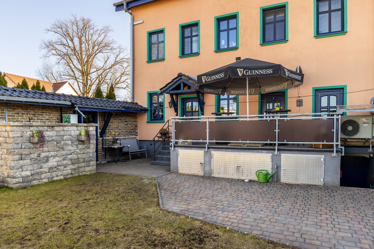 Hausfassade mit Terrasse und Sonnenschirm, Apartment über dem Pub in Michendorf, Brandenburg