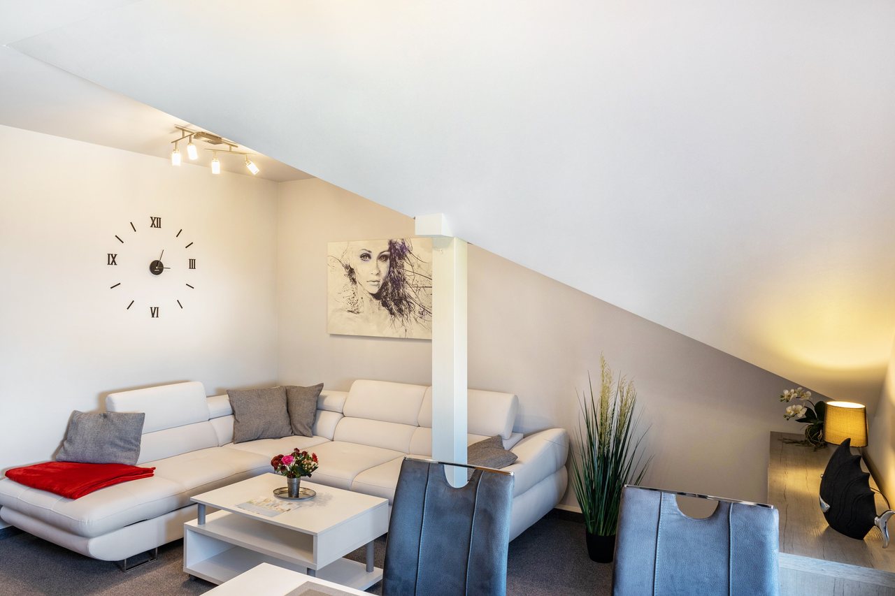 Wohnbereich mit Ecksofa unter der Dachschräge, Apartment über dem Pub in Michendorf, Brandenburg