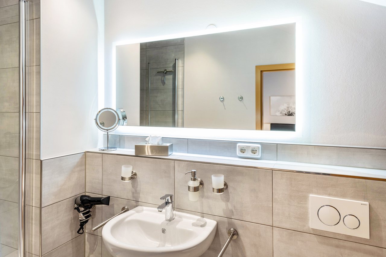 Badezimmer mit Waschbecken und Spiegel, Apartment über dem Pub in Michendorf, Brandenburg