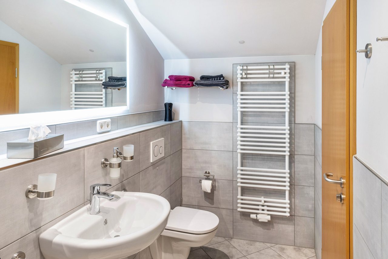 Badezimmer mit Waschbecken und Handtuchheizung, Apartment über dem Pub in Michendorf, Brandenburg