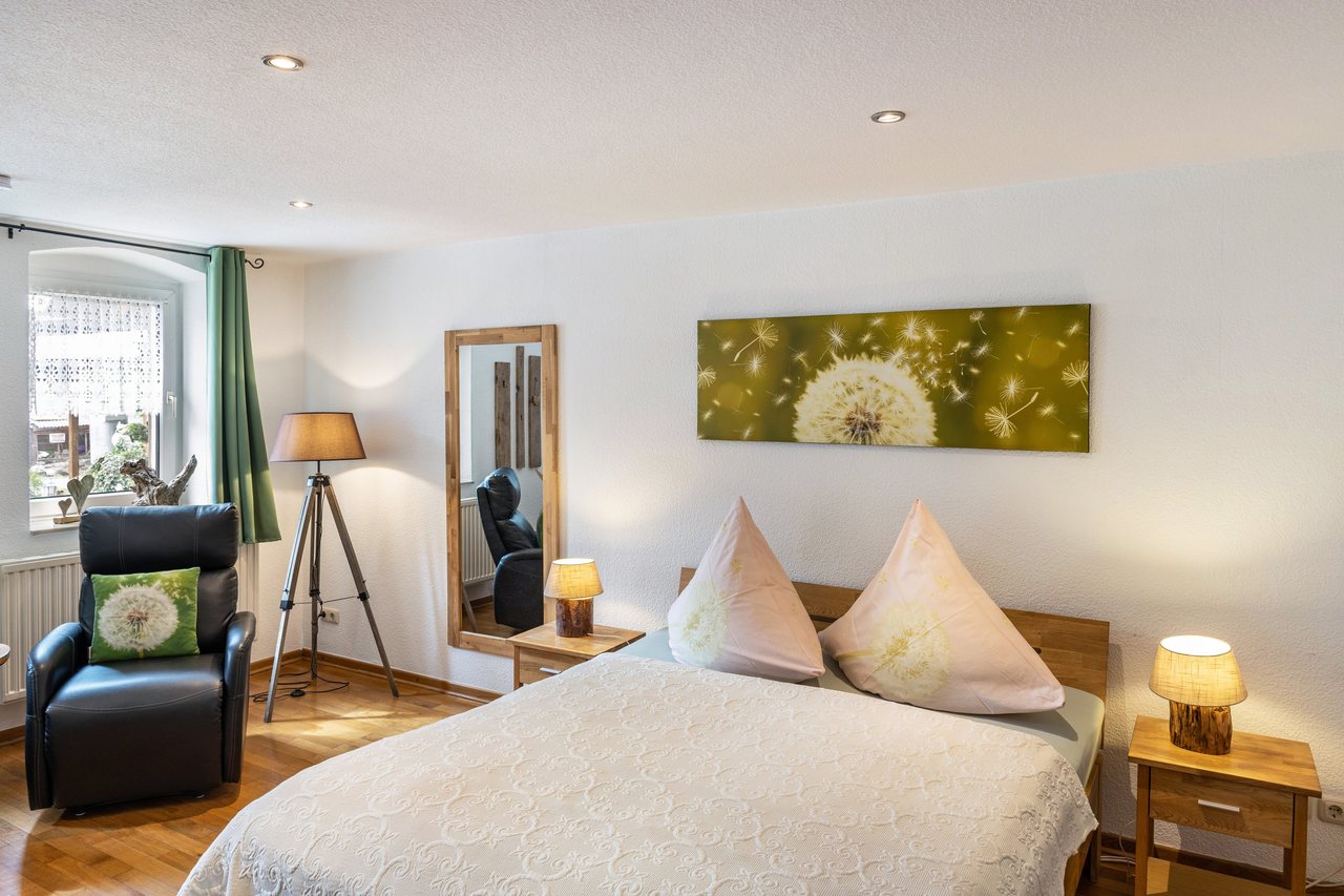Schlafzimmer mit Sessel und Spiegel, Ferienwohnung An der Wublitz in Werder, Brandenburg