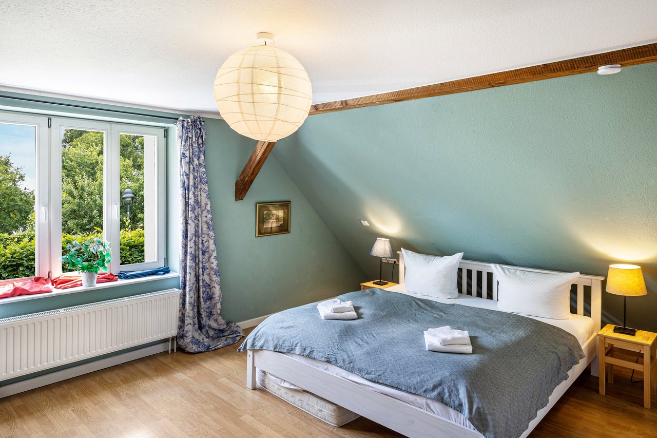 Schlafzimmer mit Doppelbett unter der Dachschräge, Radfahren Haus auf der Insel Werder in Werder, Brandenburg