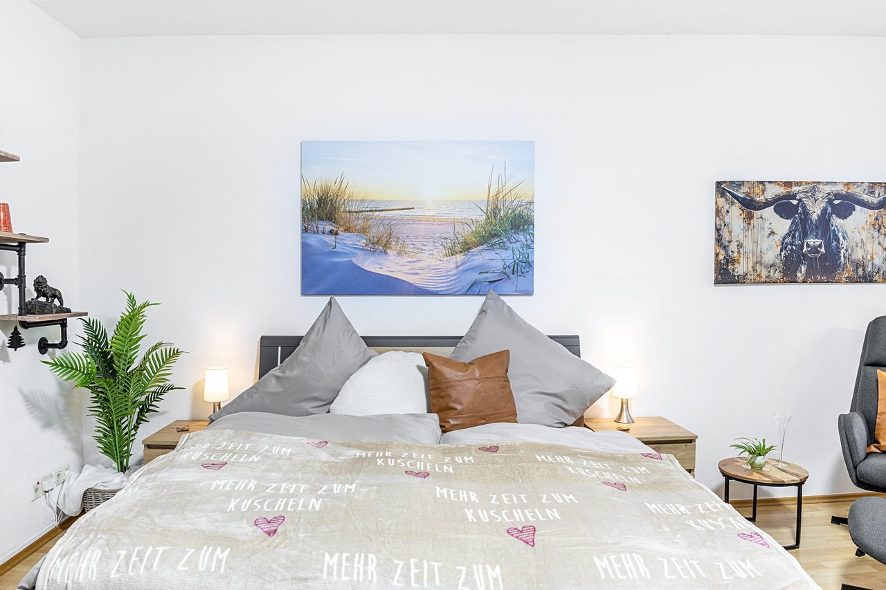 Schlafzimmer mit Doppelbett und Wandbildern, Angie’s Ferienapartment Thermalbad in Bad Staffelstein, Bayern