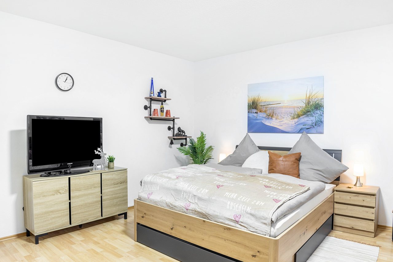 Schlafbereich mit Doppelbett und Fernseher, Angie’s Ferienapartment Thermalbad in Bad Staffelstein, Bayern