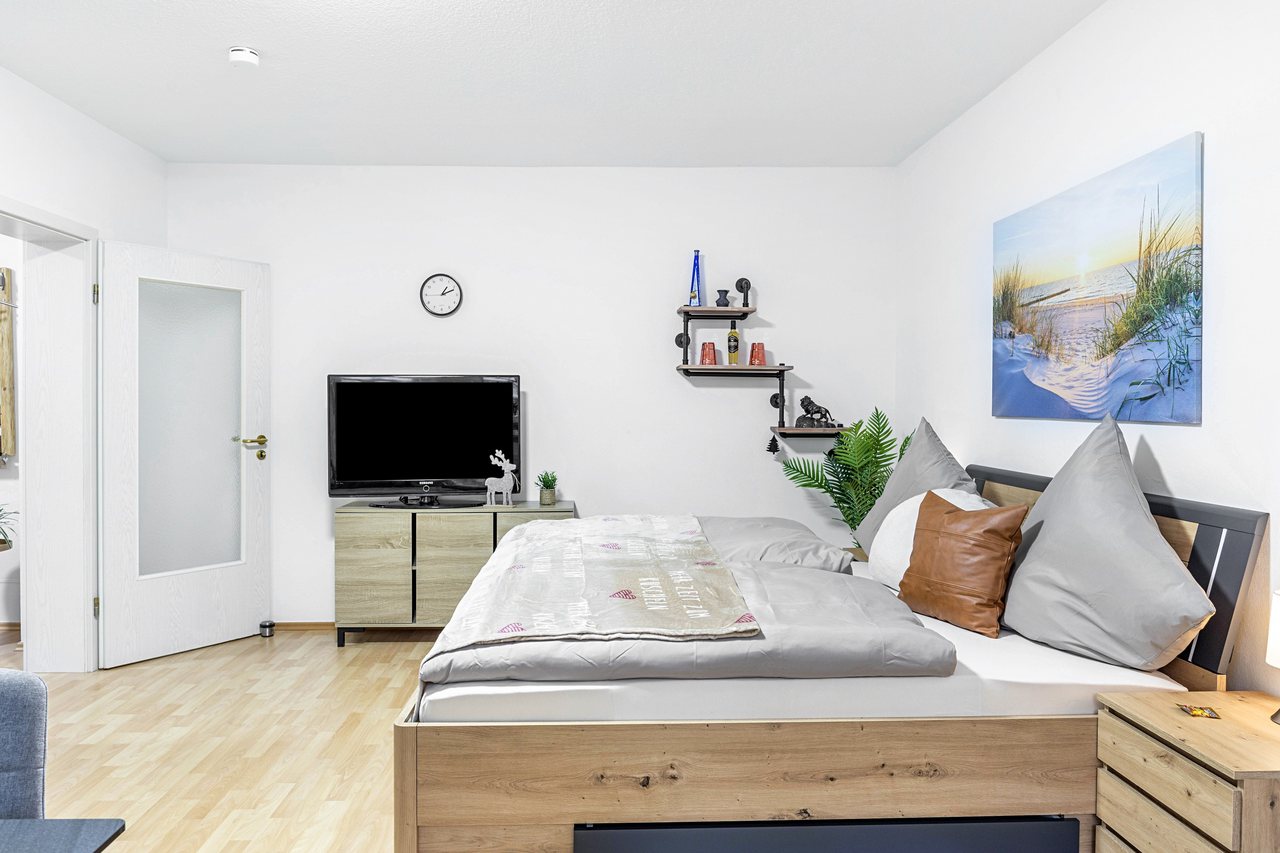 Schlafbereich mit Doppelbett und Fernseher, Angie’s Ferienapartment Thermalbad in Bad Staffelstein, Bayern