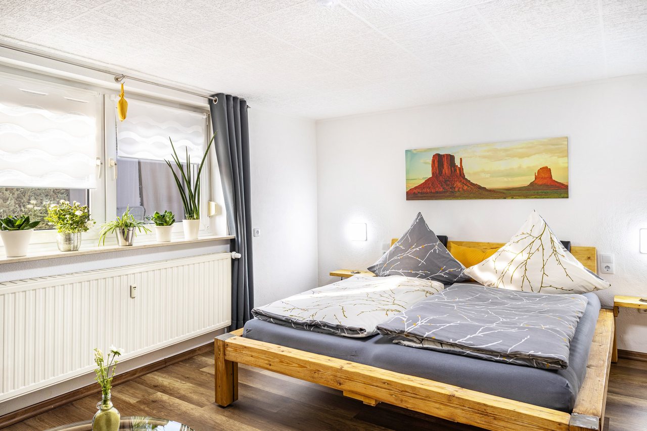 Schlafbereich mit Doppelbett am Fenster, Angie’s Ferienapartment in Lichtenfels, Bayern
