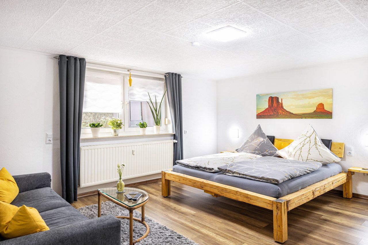 Schlafbereich mit Bett und Sofa, Angie’s Ferienapartment in Lichtenfels, Bayern