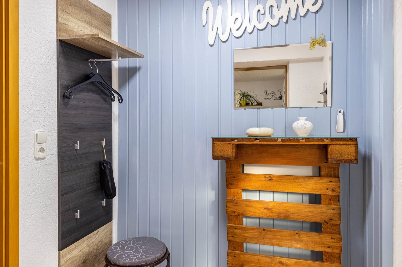 Flur mit Garderobe und Spiegel, Angie’s Ferienapartment in Lichtenfels, Bayern