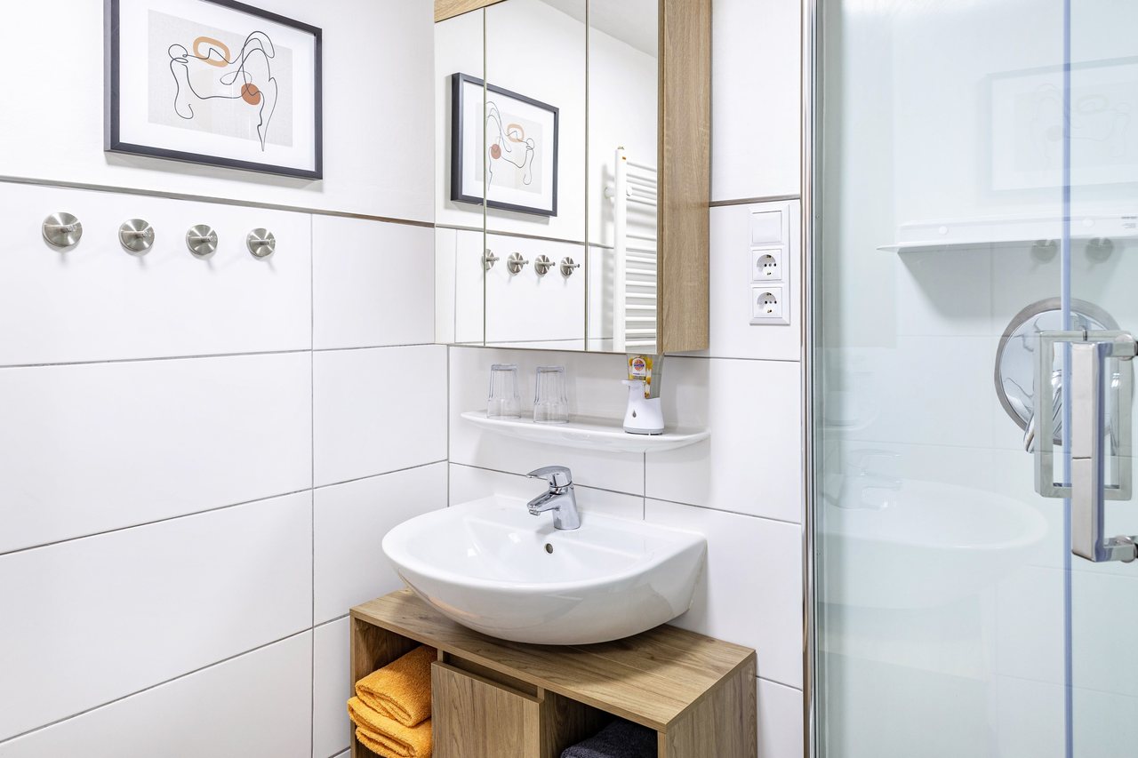 Badezimmer mit Waschbecken und Dusche, Angie’s Ferienapartment in Lichtenfels, Bayern