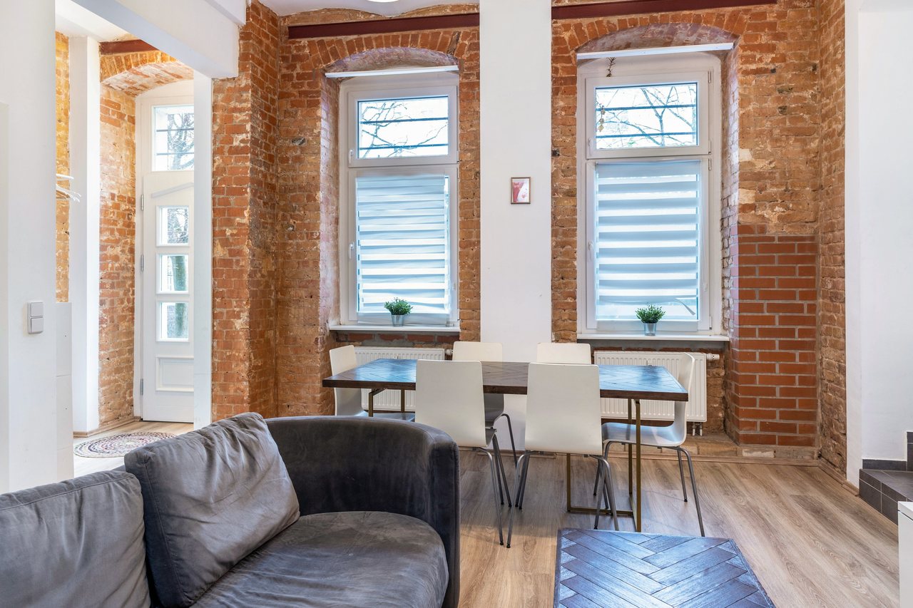 Wohnbereich mit Sofa vor Backsteinwand, Backyard Loft West-Berlin in Berlin