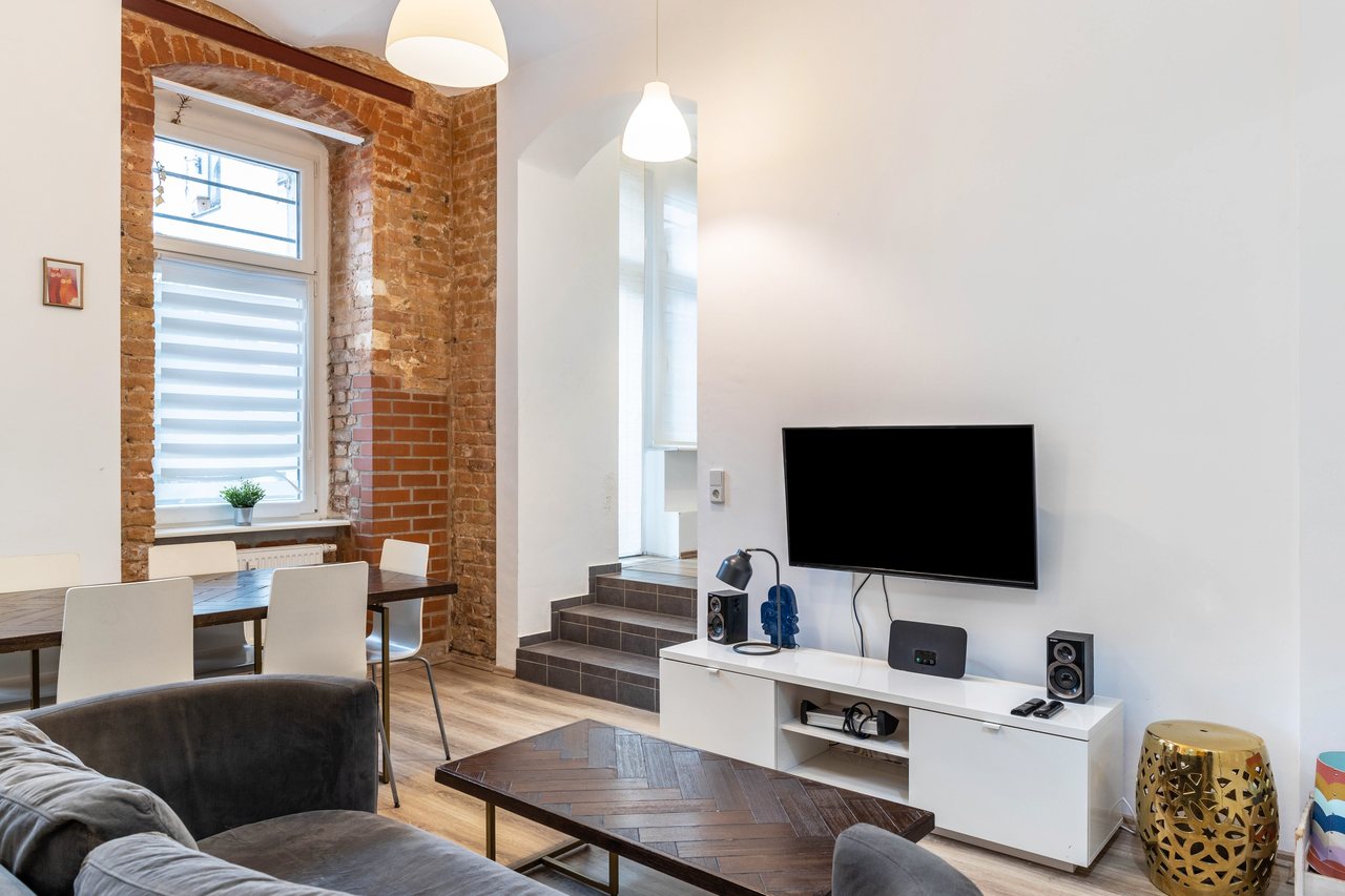 Wohnbereich mit Sofa und Fernseher, Backyard Loft West-Berlin in Berlin