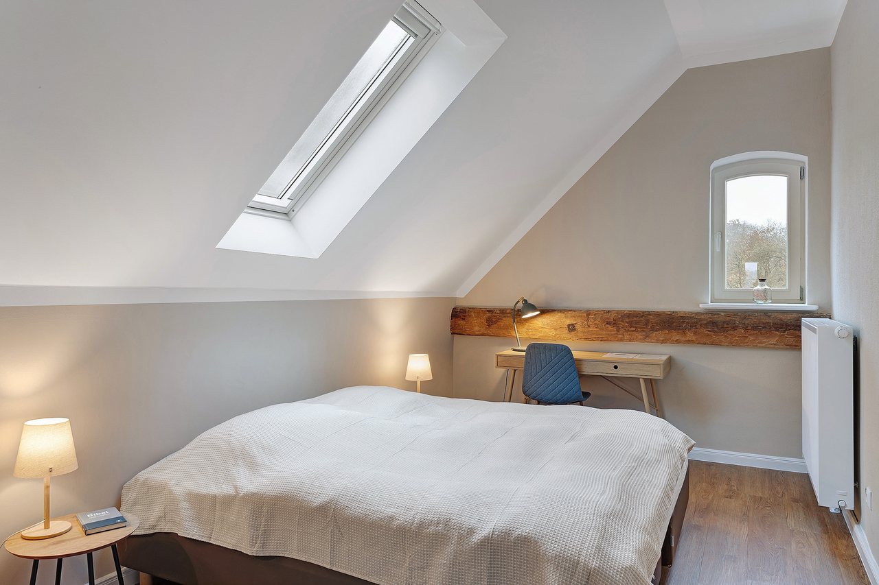 Doppelbett mit Nachttisch unter der Dachschräge, Doppelzimmer in Marienfließ, Brandenburg