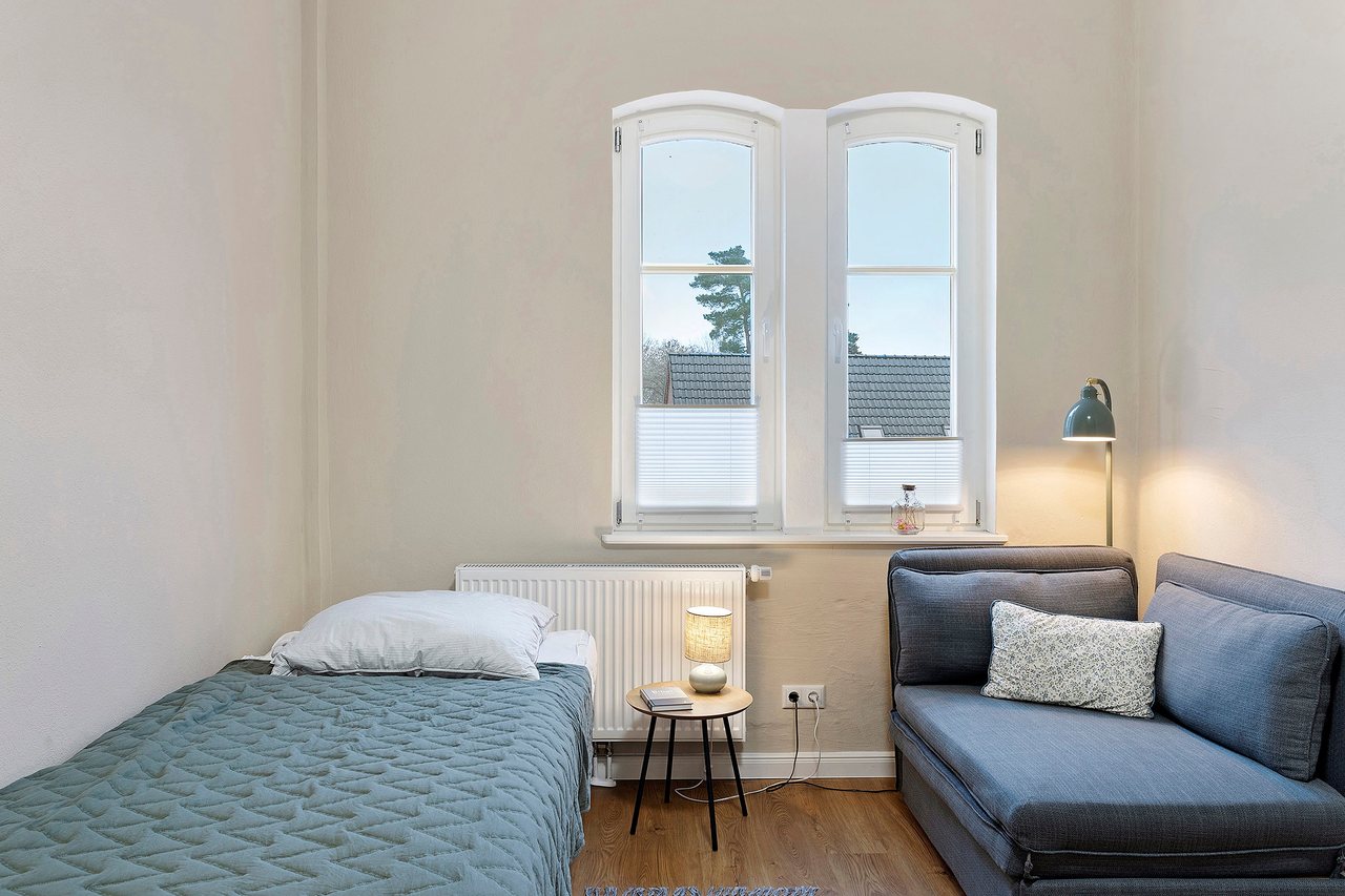 Bett mit Sessel am Fenster, Doppelzimmer in Marienfließ, Brandenburg