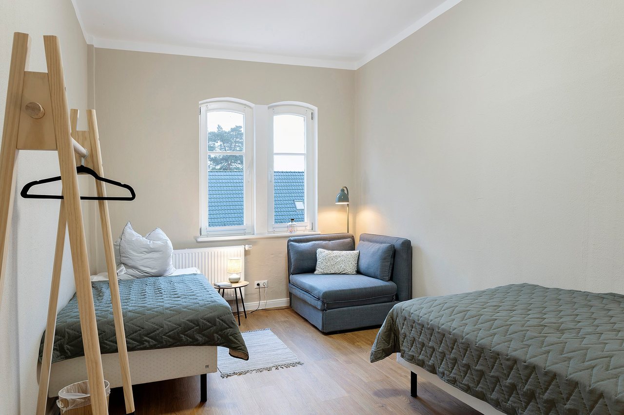 Bett mit Kleiderständer am Fenster, Doppelzimmer in Marienfließ, Brandenburg