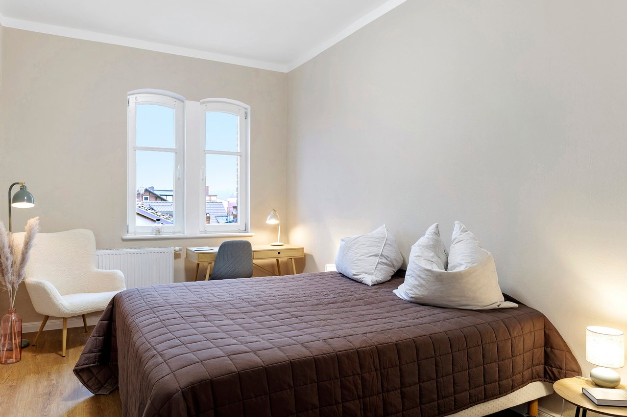 Doppelbett mit Sessel am Fenster, Doppelzimmer in Marienfließ, Brandenburg