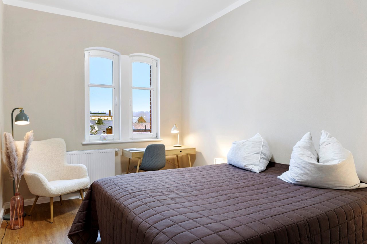 Doppelbett mit Sessel am Fenster, Doppelzimmer in Marienfließ, Brandenburg