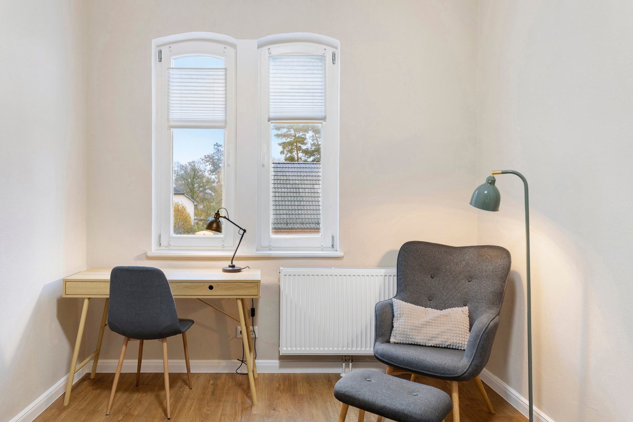 Schreibtisch mit Sessel am Fenster, Einzelzimmer in Marienfließ, Brandenburg
