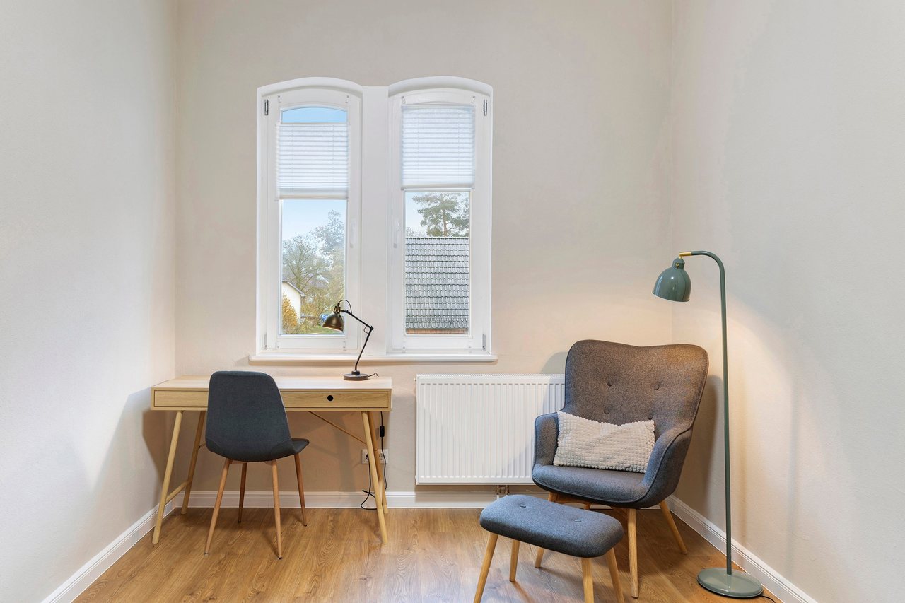 Schreibtisch mit Sessel am Fenster, Einzelzimmer in Marienfließ, Brandenburg