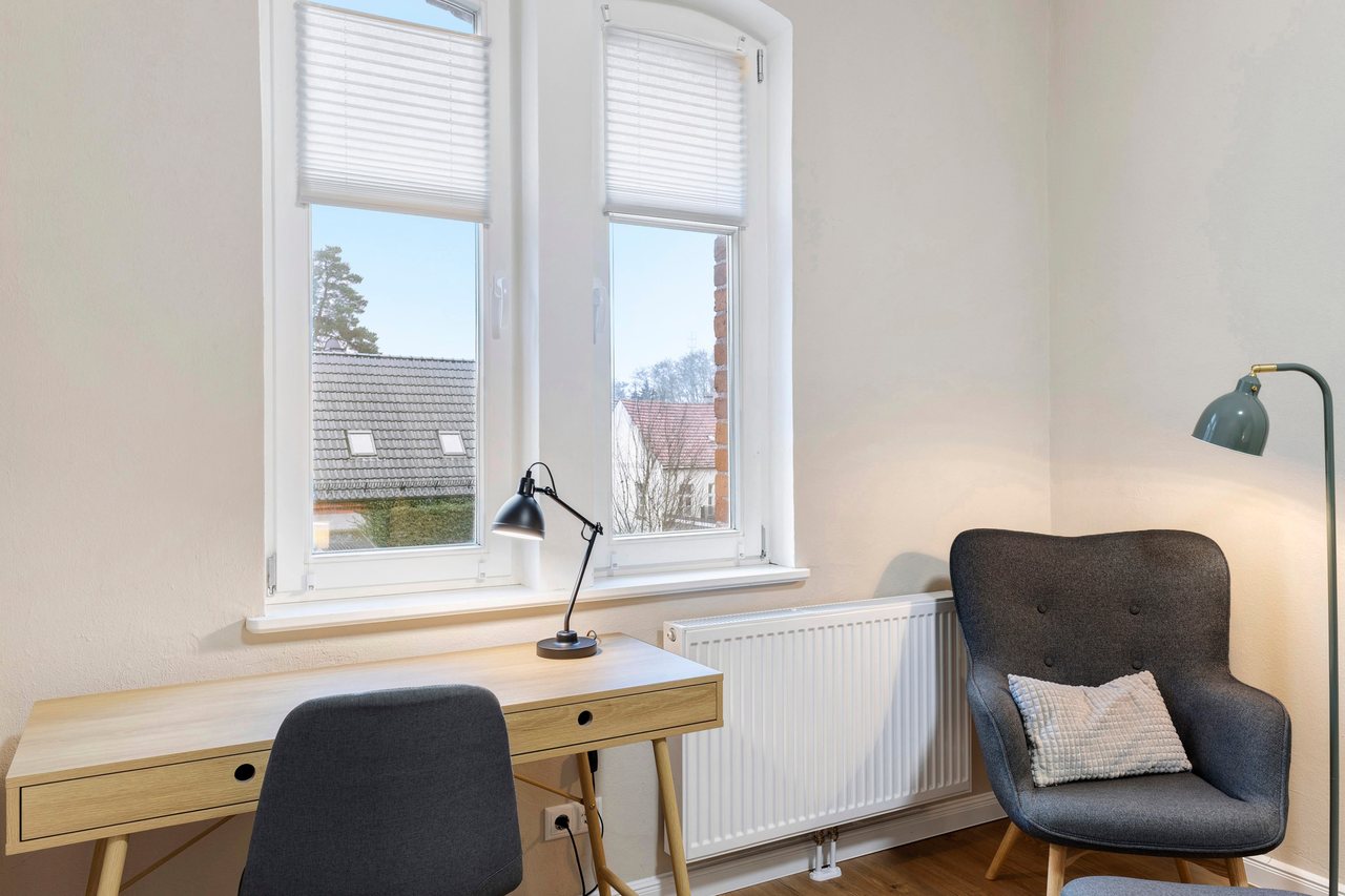 Schreibtisch mit Sessel am Fenster, Einzelzimmer in Marienfließ, Brandenburg
