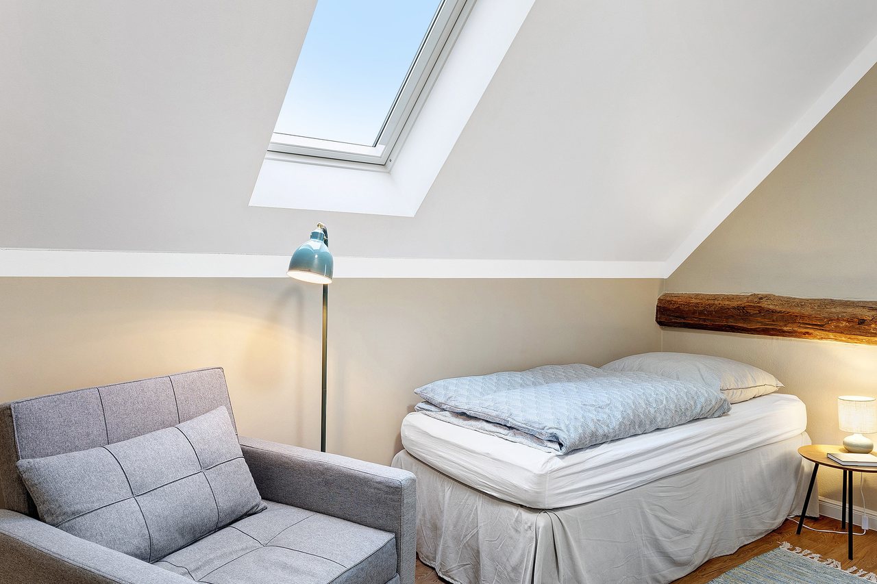 Einzelbett mit Sessel unter der Dachschräge, Einzelzimmer in Marienfließ, Brandenburg