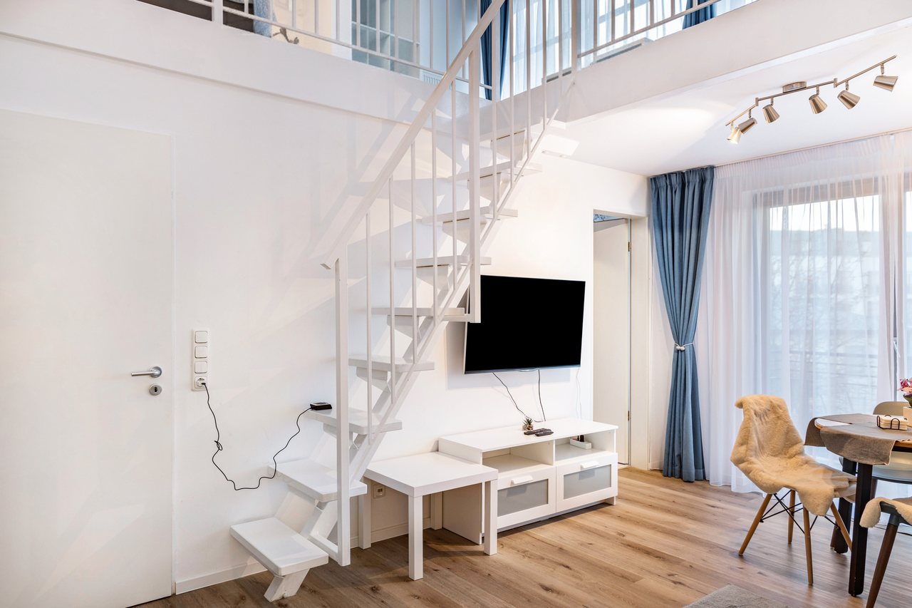 Wohnbereich mit Fernseher und Treppe, Nahe Airport BER Maisonettewohnung in Schönefeld, Brandenburg