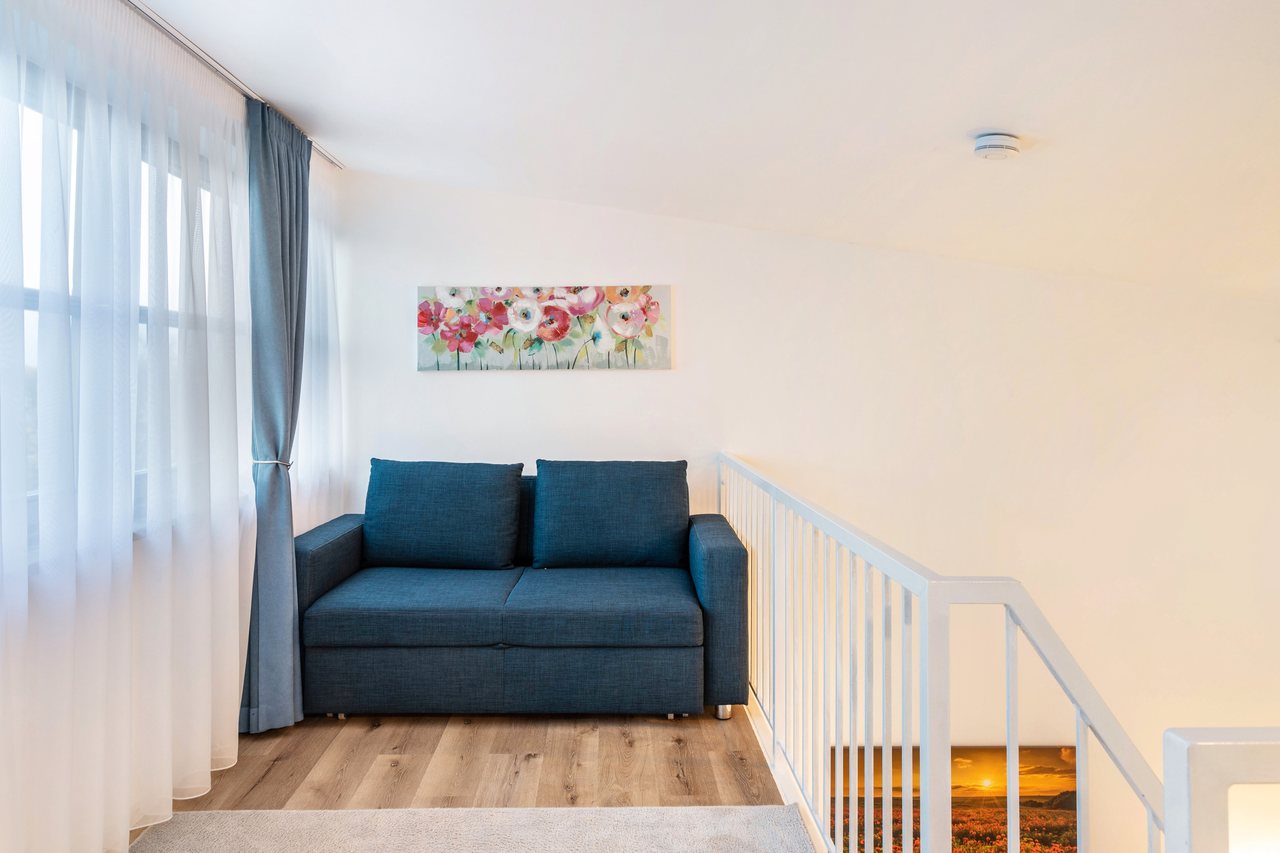 Wohnbereich mit Sofa und Treppe, Nahe Airport BER Maisonettewohnung in Schönefeld, Brandenburg