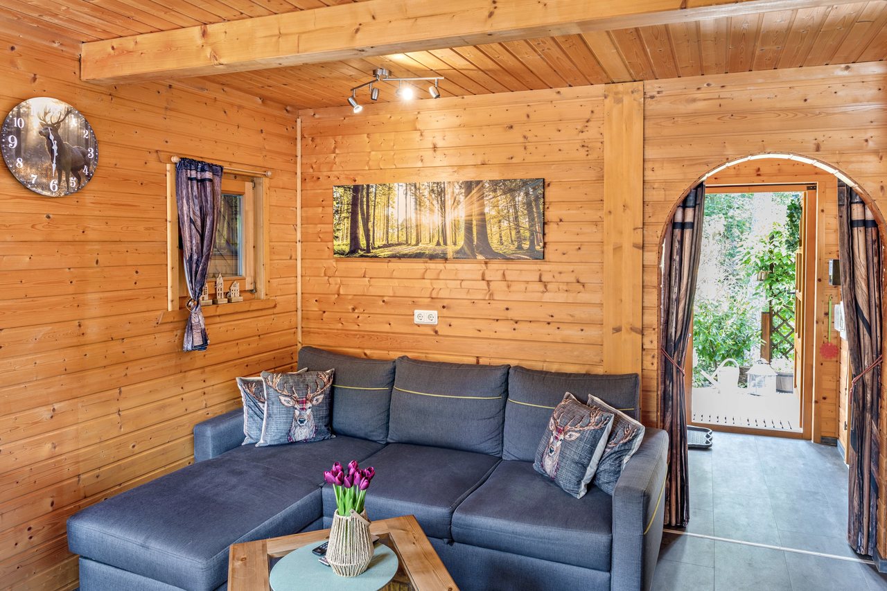 Wohnraum im Holzhaus mit Ecksofa, Ferienhaus Obert in Drognitz, Thüringen