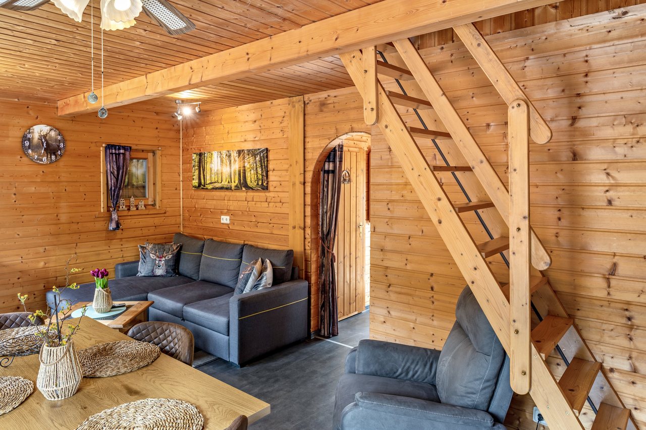 Wohnbereich mit Sofa und Treppenaufgang, Ferienhaus Obert in Drognitz, Thüringen