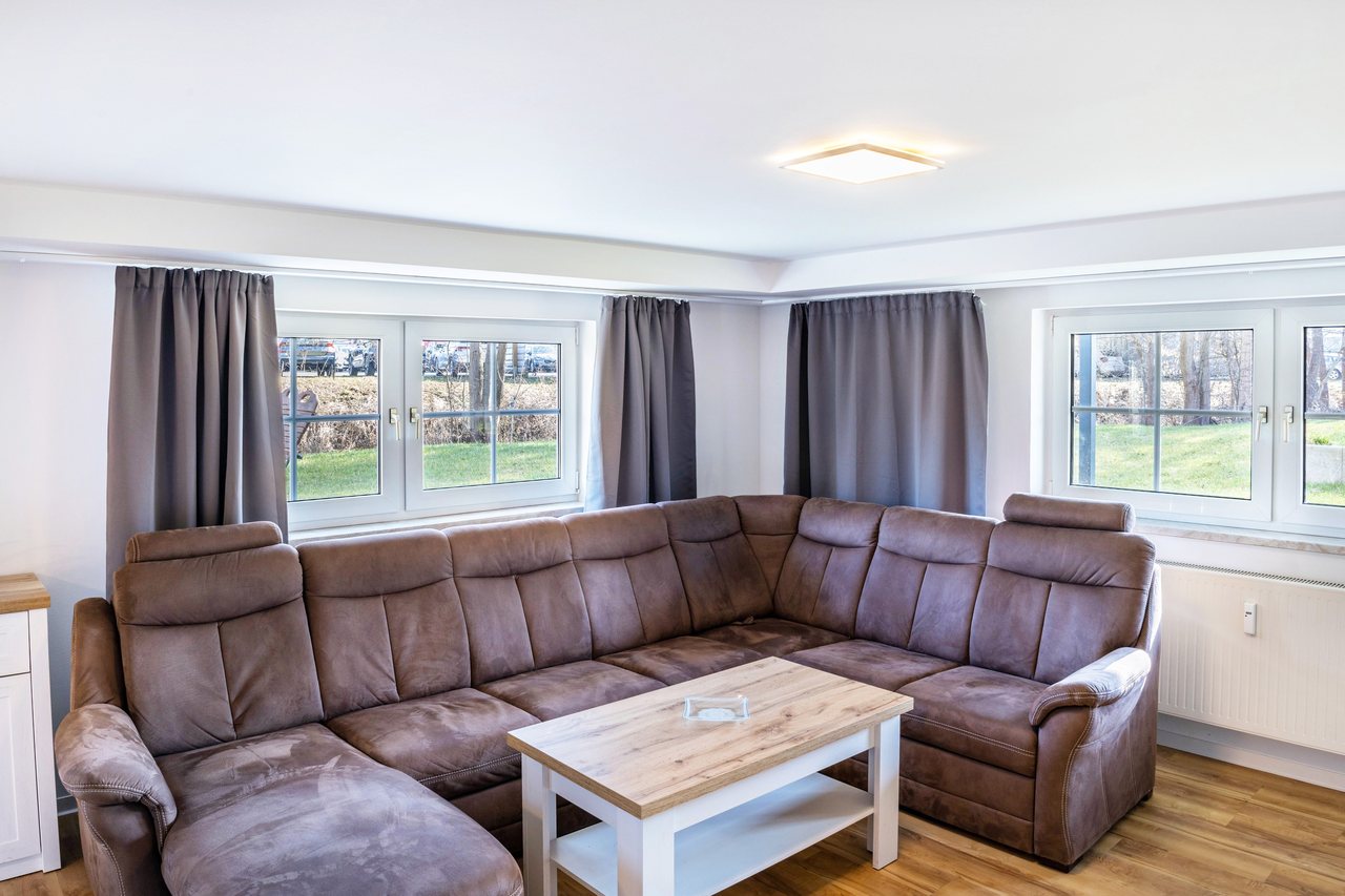 Wohnzimmer mit Ecksofa am Fenster, Haus am Eschenbach in Föritztal OT Neuhaus-Schierschnitz, Thüringen