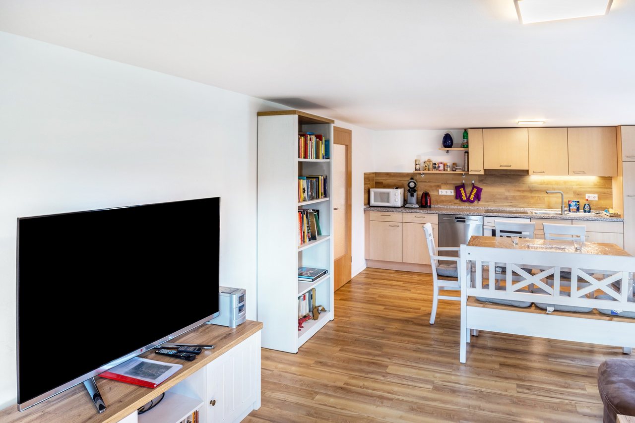 Wohnbereich mit Fernseher und Blick zur Küche, Haus am Eschenbach in Föritztal OT Neuhaus-Schierschnitz, Thüringen