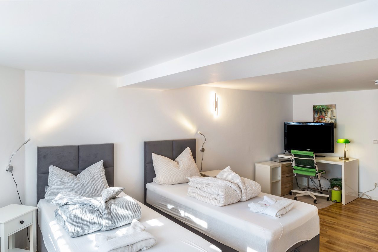 Schlafbereich mit Bett und Fernseher, Haus am Eschenbach in Föritztal OT Neuhaus-Schierschnitz, Thüringen